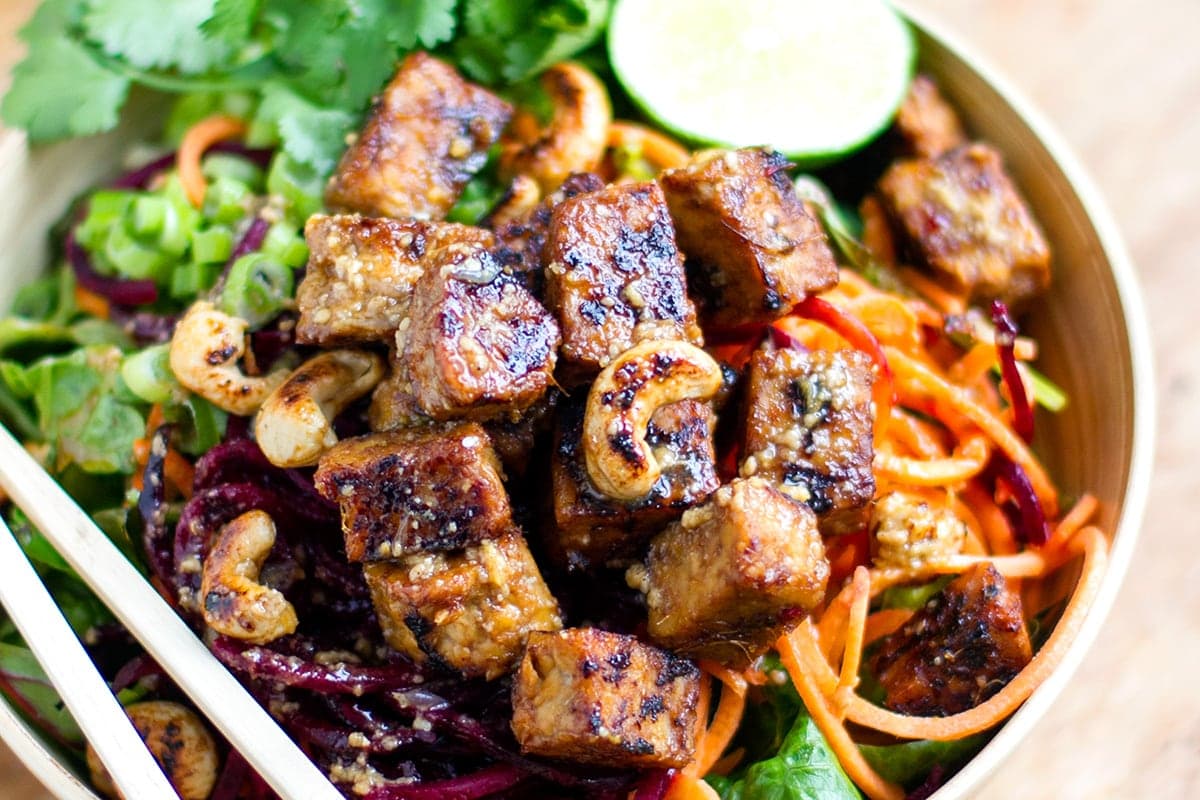 Tempeh bowls with beets, carrots and cashew nuts.