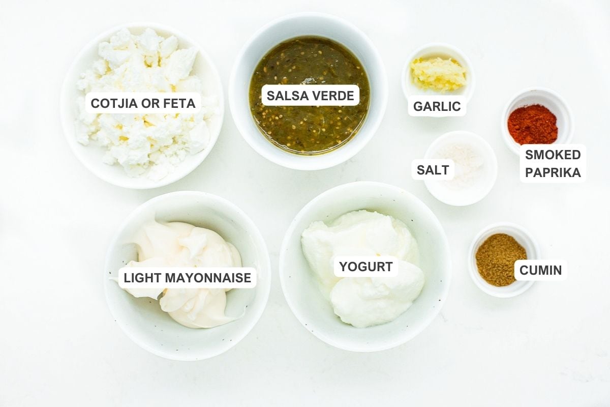 Ingredients for the recipe including salsa verde, cotija or feta, garlic, smoked paprika, salt, cumin, yogurt, and light mayonnaise.