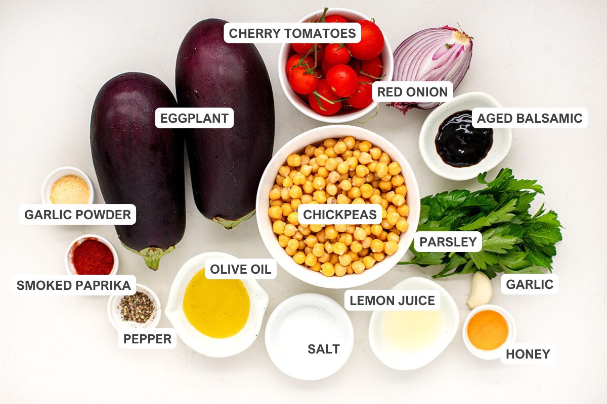 Ingredients for the recipe including eggplant, chickpeas, cherry tomatoes, red onion, parsley, aged balsamic, garlic, honey, lemon juice, salt, olive oil, pepper, smoked paprika, and garlic powder.